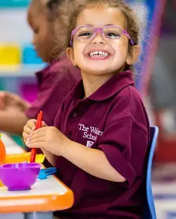 Student at table smiling widely