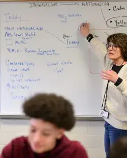 Teacher showing demonstration on whiteboard