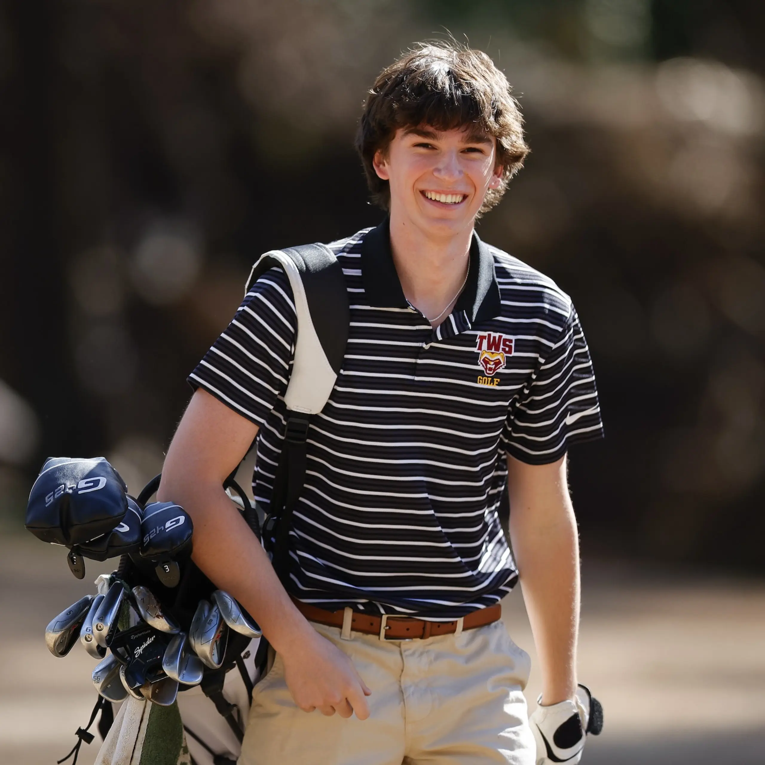 Young man carrying golf clubs