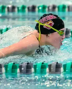 Student swimming in indoor pool