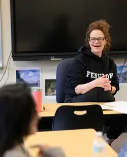 Teacher laughing at desk