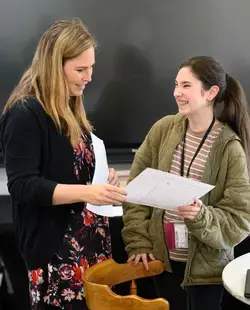 Teacher handing paper to student