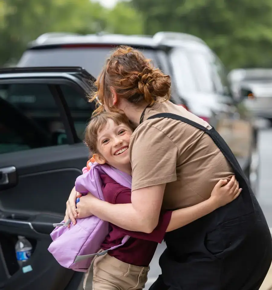 Student hugging parent goodbye at beginning of school day