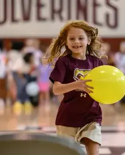 Girl running with yellow balloon