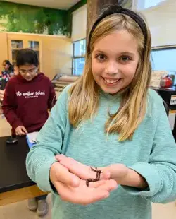 Student holding worm