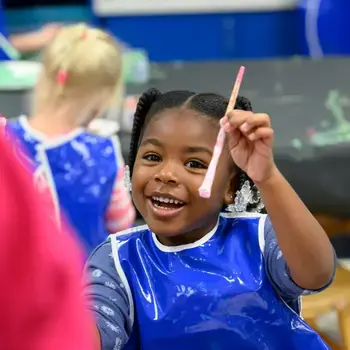 Student smiling and painting