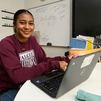 Girl smiling in front of a laptop