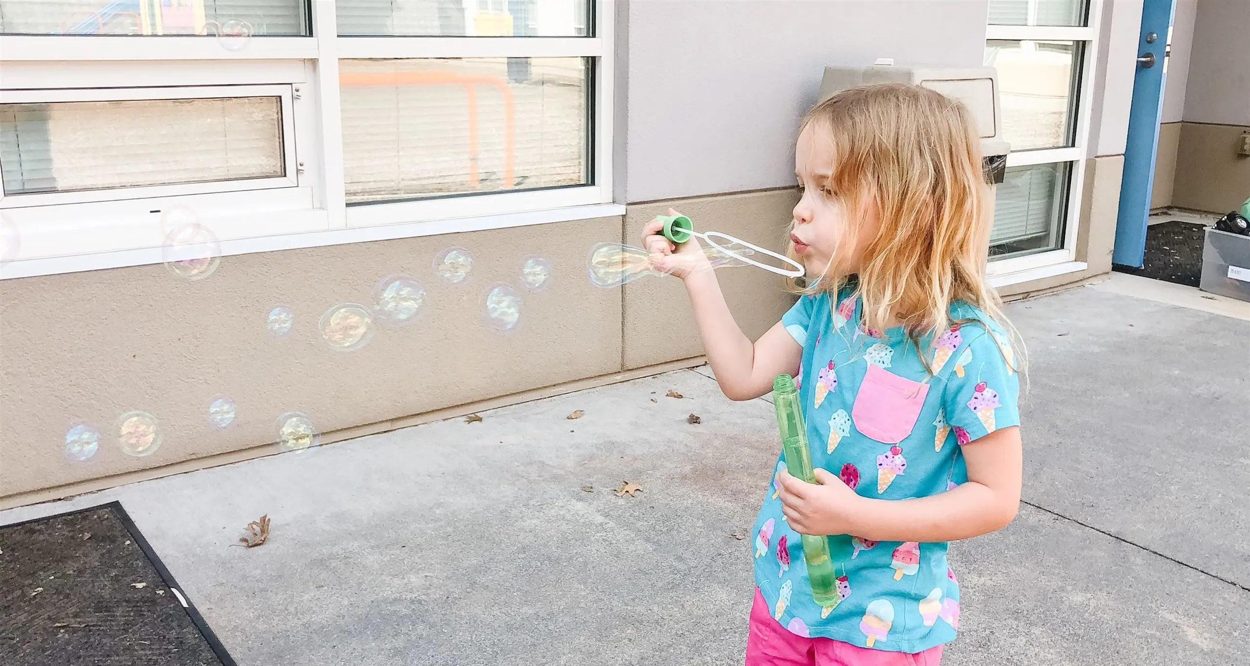 Young Walker student blowing bubbles in playground