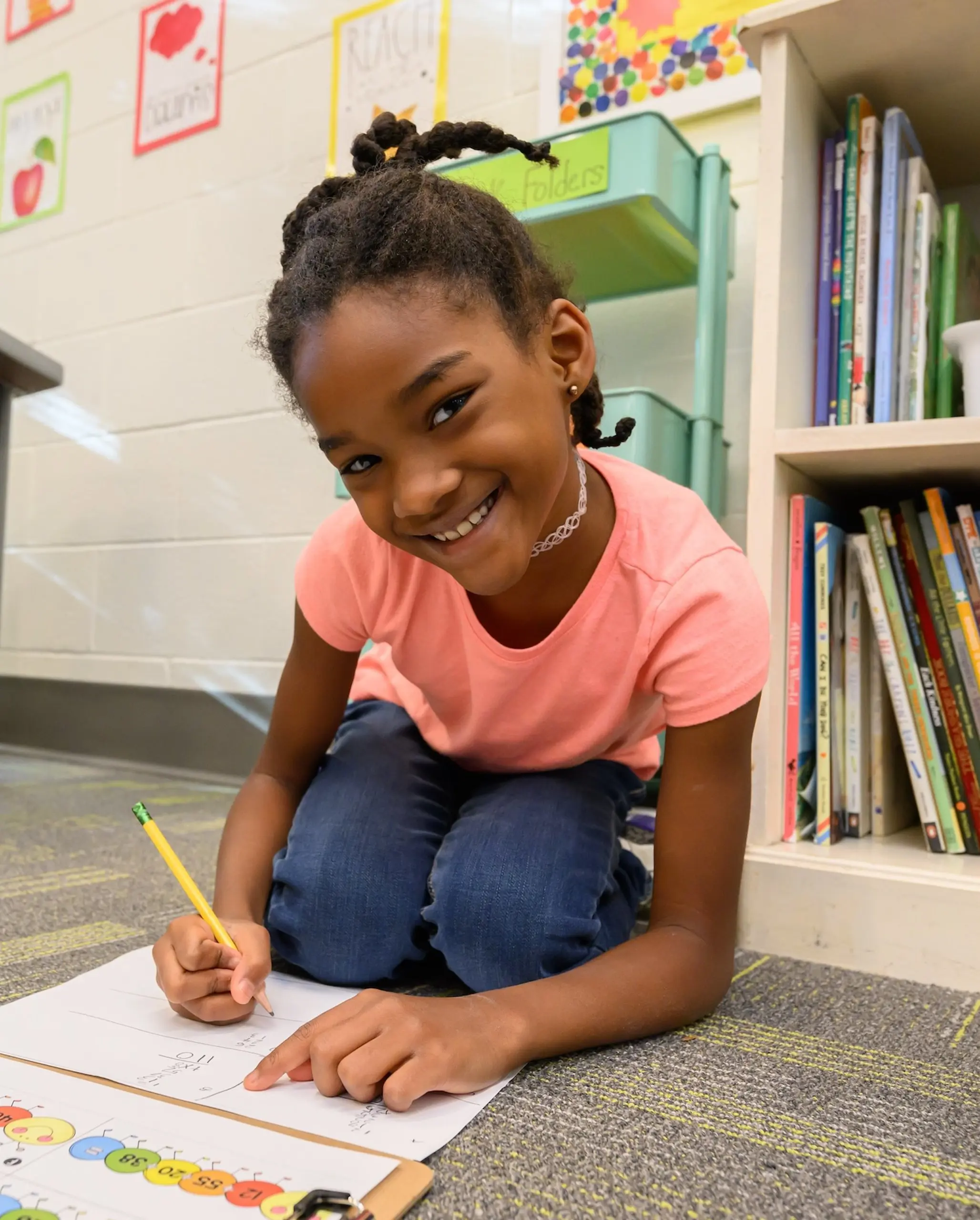 Walker student writing and smiling at camera