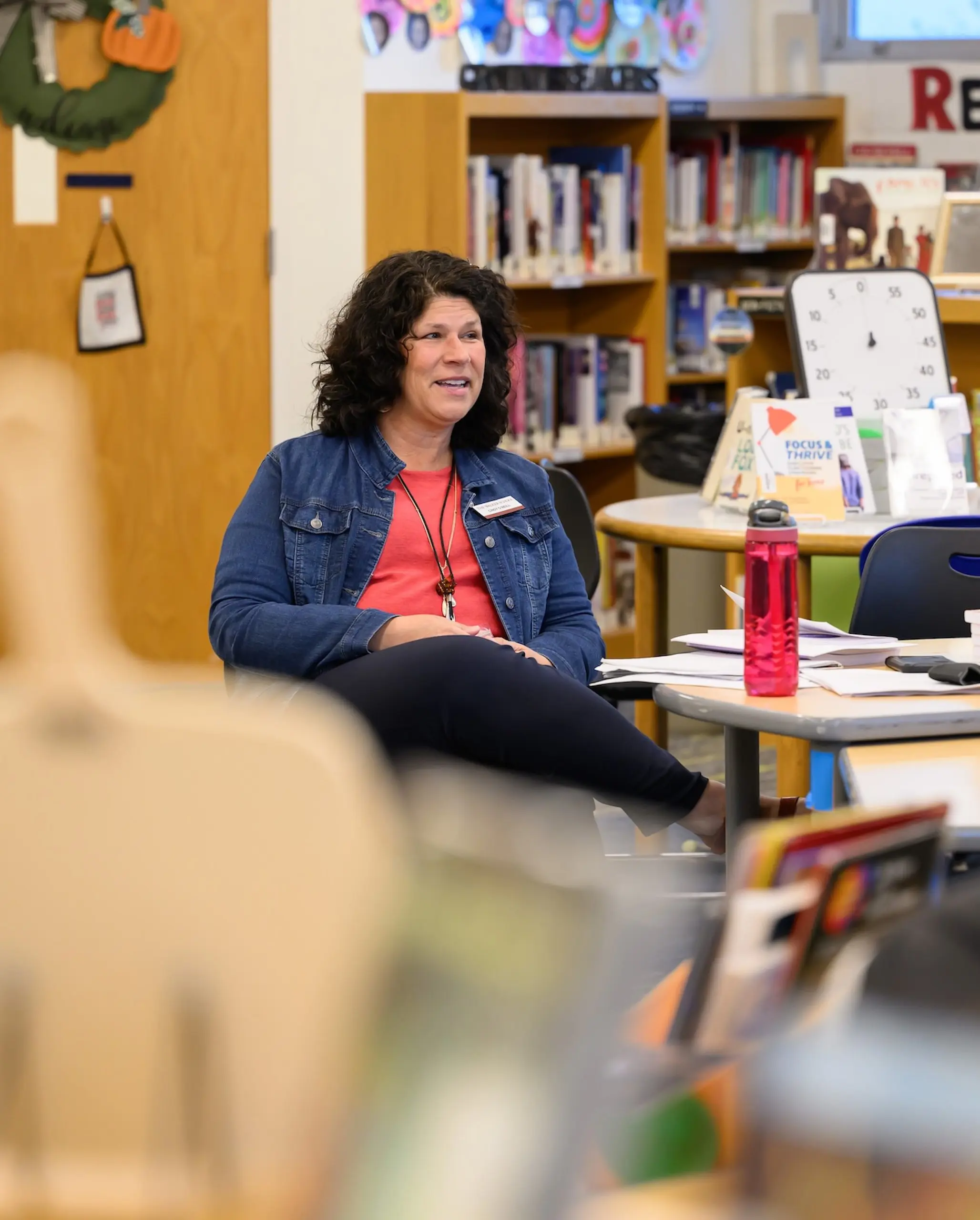 Walker teacher sitting in chair speaking to students