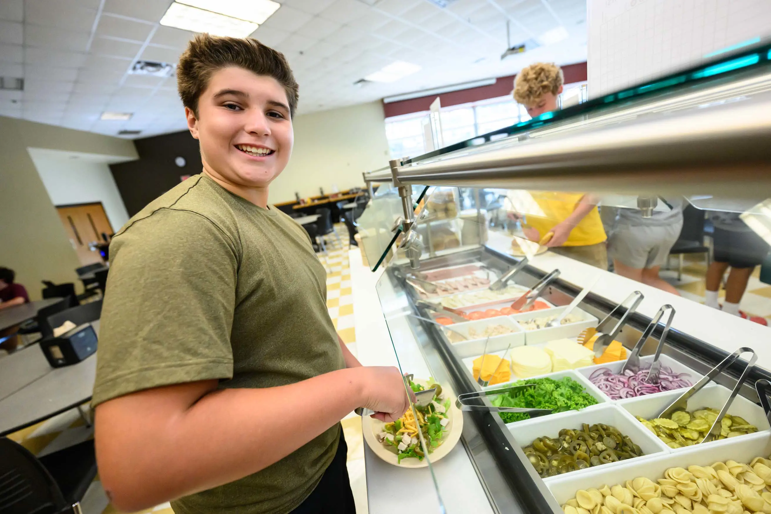 Walker student at Salad bar smiling at camera